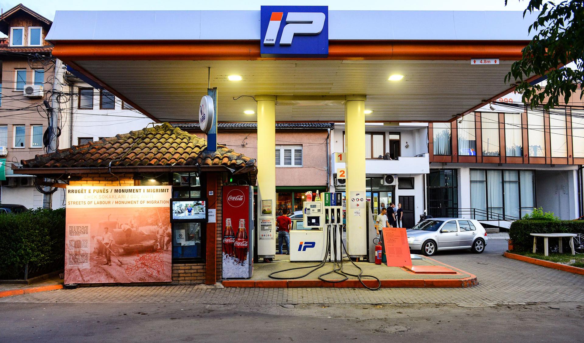 A wall of a petrol station is used as a display for historical documentation.